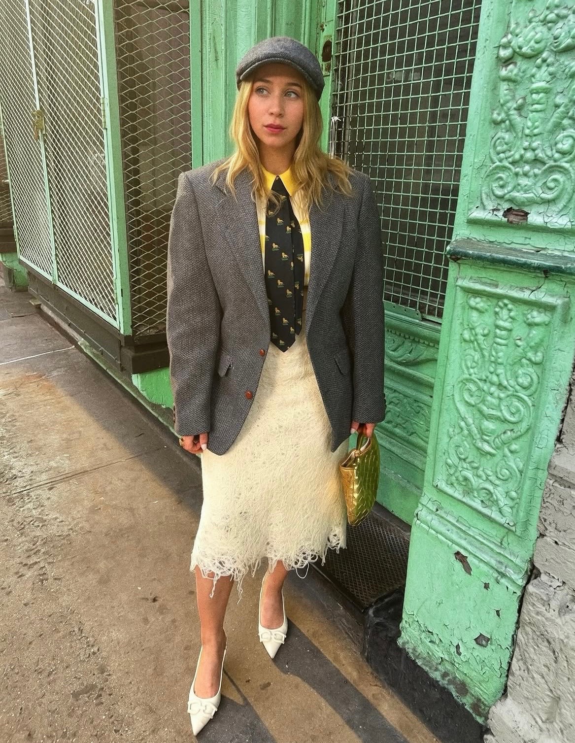 Rachel Del Rio in a grey tweed blazer and newsboy cap